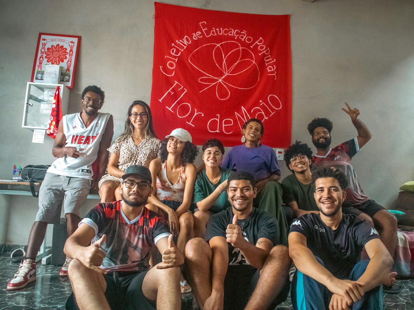 Group of friends posing cheerfully in front of a red banner.